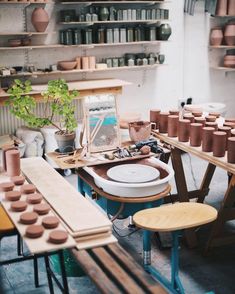 a room filled with lots of pottery on tables and shelves next to eachother