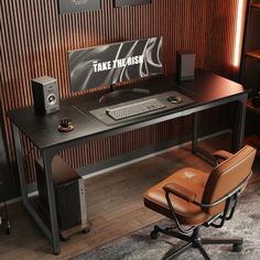 a desk with a computer and speakers on it in front of a wooden wall that says take the fish