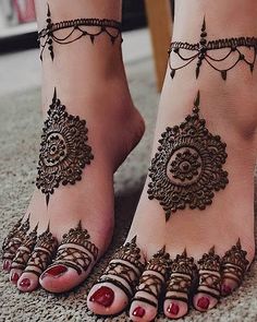 two feet with henna tattoos on them