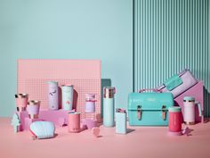 various items are arranged on a pink surface with blue and pink walls in the background