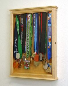 a wooden display case with many medals in it