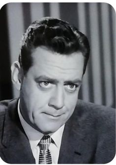 a black and white photo of a man in a suit looking at the camera with an intense look on his face