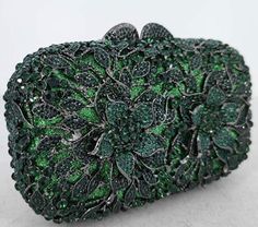 a green and black broochle on a white surface