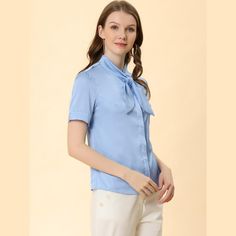 This shirt looks applicable to everyday work clothes in addition to dress-up. The silky fabric shapes this shirt with a tie-neck collared neckline and short sleeves. The curved hem gives it a neat finish over pants. The tie-neck adds casual-inspired sophistication, while soft fabric gives it an elegant, feminine shape. This elegant satin shirt features a tie-bow neck and short sleeves, making it a versatile addition to your wardrobe. Suitable for various occasions including work, office, formal Blue Collared Blouse For Work, Solid Collared Office Shirt, Collared Office Shirt With Placket, Classic Blue Blouse With Collared Neckline, Collared Shirt With Placket For Office, Tie Neck Blouse With Button Closure For Work, Classic Blue Collared Blouse, Collared Blue Shirt For Office, Office Shirt With Collared Placket