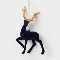 an ornament shaped like a deer with gold antlers hanging from it's back