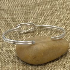 ❋ Handmade Sterling Silver Simple Dainty Knot Cuff Bracelet ❋ Size: Adjustable Women size M-L (Men size S) ❋The Length of the cuff (end to end from the outside) is about 6 3/4 inches ( / 173mm). ❋ Metal Purity: 95% Silver. (Purer than 925 Sterling Silver). To browse some more of our silver jewelry collection you can click on the following links: https://www.etsy.com/shop/SilverShapes Earrings: https://www.etsy.com/shop/SilverShapes?section_id=14809462&ref=shopsection_leftnav_1 Rings: https:/ Handmade Adjustable Minimalist Cuff Bracelet, Handmade Minimalist Adjustable Cuff Bracelet, Minimalist Handmade Adjustable Cuff Bracelet, Adjustable Nickel-free Minimalist Bangle, Simple Adjustable Bangle Cuff Bracelet, Adjustable Simple Cuff Bangle Bracelet, Simple Cuff Bangle Bracelet, Minimalist Adjustable Nickel-free Cuff Bracelet, Adjustable Minimalist Cuff Bracelet For Gift