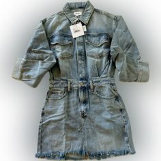 An Effortless Way To Achieve The Always Fashionable Look Of Denim On Denim. This Dress Features A Long Sleeve Button Up Top That Flows Into A Raw Hem Mini Skirt. In A True Non Stretch Denim Fabric, The Functional Pockets And Belt Loops, This Style Has All Aspects Covered. 100% Cotton Imported Chic Washed Blue Denim Dress With Pockets, Medium Wash Denim Dress With Frayed Hem, Denim Dress With Frayed Hem For Fall, Light Wash Denim Dress With Frayed Hem For Fall, Fall Light Wash Denim Dress With Frayed Hem, Light Wash Denim Mini Dress With Pockets, Dark Wash Denim Dress With Frayed Hem For Fall, Washed Blue Denim Dress With Frayed Hem, Blue Denim Dress With Frayed Hem For Fall