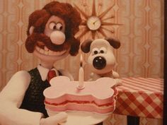 a cartoon character holding a cake with a dog next to it