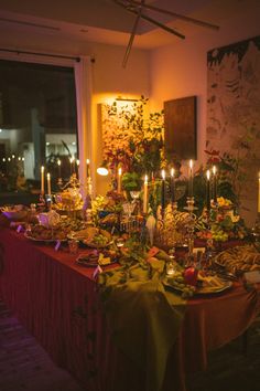 a long table covered with lots of food and candles