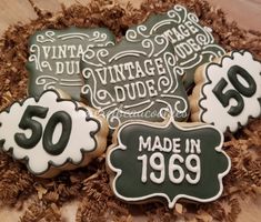 decorated cookies are sitting in a box on top of some wood shavings with the words 50 made in 1950