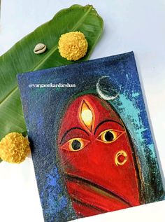 an artistic painting on a card next to some flowers and a banana leaf with the word happy diwali written in it