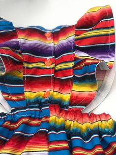 Perfect for all the summer 🥳 FIESTAS!! Handmade skirt romper. Made with cotton serape cotton fabric. These amazing pieces are made to order. Sizes 0-6 month up to 4T are made with attached bloomers and snaps at the saddle. Anything above a 4t (5t -7/8y) are the same style dress with no bloomers attached. If you have any questions on sizing please don't hesitate to message me. I will gladly help. Rainbow Cotton Dress For Playtime, Rainbow Cotton Playtime Dress, Rainbow Summer Dress For Playtime, Rainbow Summer Dresses For Playtime, Summer Rainbow Playtime Dress, Playful Multicolor Ruffled Sundress, Multicolor Summer Sundress For Playtime, Multicolor Ruffled Dresses For Festival, Multicolor Ruffled Festival Dress