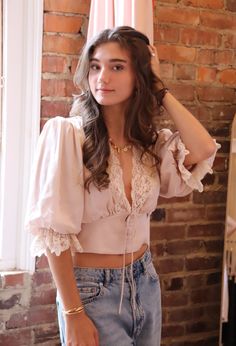 We’re blushing. This dreamy silk-like top features a soft color, plunging neckline, and delicate lace details. Content & Care: 53% Viscose, 47% Rayon Dry clean only Etheral Outfit Ideas, Kibbe Soft Classic Outfits, Feminine Outfits Girly, Ethereal Clothes, Ethereal Aesthetic Fashion, Feminine Outfit Ideas, Boutique Blouses, Soft Feminine Style, Pink Lace Top