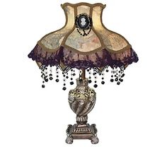 a lamp that is sitting on top of a wooden stand with beads hanging from it