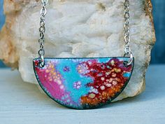 Wear a piece of original art with this enamel necklace. Abstract design is created with a torch and powdered enamel glass in colors of sky blue, orange, black, pink, red and white. Dangles from a stainless steel chain with silver plated lobster claps. I only made one...so you will have a unique necklace!  I have more enamel necklaces: https://www.etsy.com/shop/Gypsymoondesigns?ref=seller-platform-mcnav&section_id=36107042 Measurements Pendant is 3/4 inches long and 1 1/2 inch wide. 18 inches lon Red Handmade Enamel Necklaces, Handmade Red Enamel Necklaces, Handmade Red Enamel Necklace, Red Hand Painted Pendant Necklaces, Handmade Pink Enamel Necklaces, Multicolor Enamel Jewelry With Black Details, Unique Red Enamel Necklaces, Multicolor Enamel Pendant Necklaces, Multicolor Hand Painted Enamel Necklaces