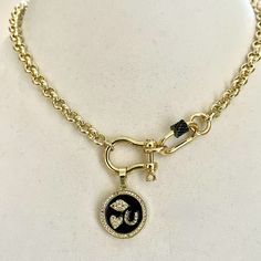 This is an elegant gold Rolo chain shackle necklace with a pictogram charm set atop of a black enamel background making the "I love you" stand out in a charming yet playful way. Lobster closure. The gunmetal CZ screw carabiner makes this piece classy and unique. It is the absolute perfect gift for her. The brass round link Rolo chain is gold plated and both lead and nickel safe. Approximate Chain link size - 6mm Approximate shackle size - 18x12mm Pendant Charm - 20mm Care instructions To keep yo Double Horn Necklace, Clean Fast, Hand Knotted Necklace, Beautiful Gold Necklaces, 18k Gold Necklace, Infinity Necklace, Gold Necklace Designs, Gold Necklaces, Necklace Online