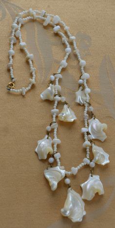 "Pretty vintage white mother of pearl shell beaded necklace is fun and funky. It is long and measures 27\" in length. The necklace is in very good vintage condition and has a spring ring clasp." Handmade Retro White Necklace, Handmade Vintage White Necklace, White Single Strand Mother Of Pearl Beaded Necklaces, White Single Strand Mother Of Pearl Beaded Necklace, Vintage White Single Strand Beaded Necklaces, Vintage White Single Strand Beaded Necklace, Vintage White Beaded Jewelry, Vintage White Single Strand Necklace, Vintage White Adjustable Necklace