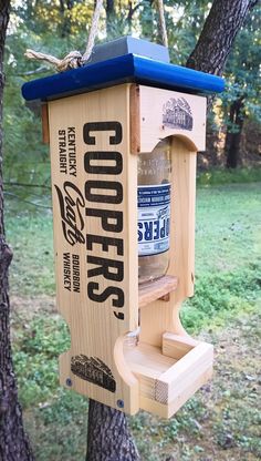 a wooden bird feeder hanging from a tree