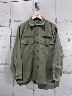 70's OG-107 Fatigue Button Up Shirt- Vietnam War(Army Green)  Great vintage condition. See pictures for condition no size tag . Please review measurements as some vintage items fit smaller than modern sizing. Measurements taken with garment laid flat: 21" across from armpit to armpit 29.5" length from shoulder to hem 27" sleeve from shoulder to hem Please send a message if you have any questions. Double check measurements and inspect all pictures carefully before purchasing. Orders ship via USPS Retro Khaki Button-up Shirt, Vintage Khaki Tops With Snap Buttons, Vintage Buttoned Tops For Streetwear, Vintage Khaki Button-up Shirt, Vintage Khaki Shirt With Button Closure, Vintage Streetwear Shirt With Pockets, Vintage Green Shirt For Streetwear, Retro Buttoned Tops For Streetwear, Retro Button Tops For Streetwear