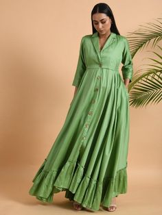 A shawl collared cotton silk maxi dress with flared and flounced bottom, side pockets, and long sleeves Garment measurements (in Inches): Small: Bust - 39", Waist - 29" Medium: Bust - 42", Waist - 32" Large: Bust - 45", Waist - 35" Length: 55-56", Sleeve length: 17" Fabric: Cotton Silk Color: Green Fit: Model height is 5'7" Model is wearing a size S Loose and comfortable fit. Instructions: Hand wash separately in cold water Note: Available in other colors Pants not included with the product Pant Cotton A-line Maxi Dress With Ruffles, Spring Long Sleeve Gown With Ruffles, Elegant Green Cotton Maxi Dress, Green Long Sleeve Summer Gown, Festive Ruffled Maxi Dress, Festive Maxi Dress With Ruffles, Fitted Long Maxi Dress With Ruffles, Festive Ruffled Long Sleeve Dress, Festive Long Sleeve Dresses With Ruffles