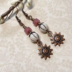 Super cute boho earrings perfect for everyday!  These are created using white Czech glass melon beads with a brown wash, pink Strawberry Quartz rondelles, and antique copper sun charms.  I have also used antique copper accents, and nickel free, fish hook ear wire.  Total length of earrings, including the ear wire, is approximately 2-1/4".    Thank you for shopping with The Lucie Collection! Earth Tone Earrings, Nickel Free White Bohemian Earrings, Bohemian Pink Wire Wrapped Beaded Earrings, Nickel-free White Bohemian Earrings, Bohemian Nickel-free White Earrings, White Czech Glass Dangle Jewelry, Bohemian White Nickel-free Earrings, White Adjustable Bohemian Beaded Earrings, White Bohemian Beaded Earrings Nickel Free