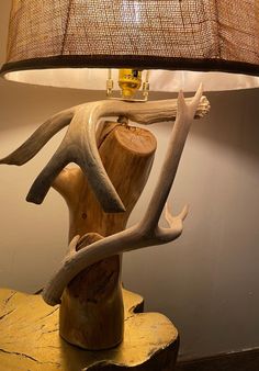 a lamp that is sitting on top of a wooden table next to a deer head