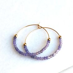 Tanzanite Gold Hoop Earrings D E T A I L S These gorgeous hoop earrings are created with Genuine Natural Tanzanite 3mm beads and 14kt gold filled accents   Beaded by hand  14kt gold filled 35mm hoops  ∙ EXTRA LOVE ∙ Crafted and curated just for you in the desert of our Arizona studio. All of our jewelry comes gift packaged!  We are happy to leave a note if this is a special gift, just let us know in the message box at checkout.  PRODUCTION ∙ TIMES All items are made to order. Please check the top of our policies page for the most current production time before shipping. If you need it sooner, select a faster shipping at checkout.  ∙ What is gold filled? ∙ Gold filled jewelry is beautiful long lasting material, it is very durable and will not chip or turn colors. With proper care it can las Faceted Hoop Earrings As Gift, Faceted Hoop Jewelry For Gifts, Purple Hoop Earrings As Gift, Jewelry Hoop Earrings, Earrings Gold Hoop, Tanzanite Jewelry, Tanzanite Earrings, Gift Best Friend, Hoop Earrings Gold