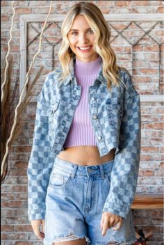 Denim jackets are a fashion staple. This denim shirt jacket features two denim colors woven into a unique checkered pattern. The crop styling features a four button front, button flap pockets and button cuffs. It has a back straight yolk accented with off-center pleats. The double top stitched collar has rounded points and the jacket has an unfinished hem. This is the perfect topper for sun dresses and anytime you need a medium-weight layer. Woven Two-Tone Denim Checkered Pattern Button Front, P Spring Plaid Denim Outerwear, Casual Gingham Outerwear With Pockets, Chala Handbag, Denim Shirt Jacket, Sun Dresses, Handbag Charms, Curvy Dress, Denim Jackets, Checkered Pattern