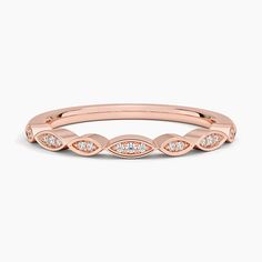 a rose gold wedding band with diamonds on the sides and an oval design in the middle