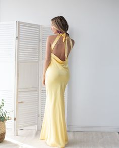 Ana es un vestido largo, confeccionado en tela semi satinada. Posee escote halter y dos tirantes ajustables que se anudan al cuello y acaen hacia la espalda. El diseño es liso hasta el ruedo. Es semi ajustado en las caderas y cae recto hacia el ruedo. Su espalda posee es rebajada hasta la cintura baja, terminando con un drapeado que cae suelto. Este vestido, lo puedes usar de día y de noche, en matrimonios al aire libre o interior, graduaciones y eventos corporativos. Este es un vestido liviano, que hará lucir tu figura, además sus tirantes ajustables harán que te sientas cómoda y segura. Importado de USA. Tela