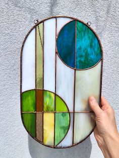 a hand holding up a stained glass piece