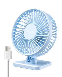 a blue fan sitting on top of a table next to a charger and plugged in