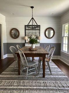 a dining room table with chairs and a rug on the floor