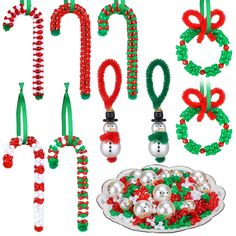 christmas decorations and ornaments are arranged on a white surface with green, red and white ribbons