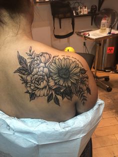 the back of a woman's shoulder with flowers on it