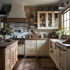 a kitchen filled with lots of wooden cabinets and counter top space next to a window