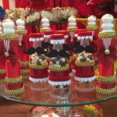 a table topped with lots of red and white candy covered in decorations on top of a glass plate