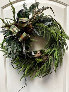 a wreath is hanging on the front door with green leaves and other things around it