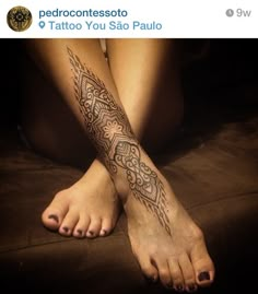 a woman's leg with a tattoo on it and her legs crossed out to the side