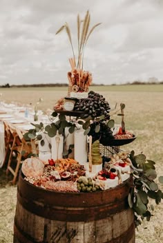 a barrel with food on it in the middle of a field