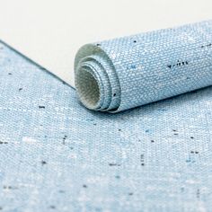 a rolled up piece of blue fabric on top of a white tablecloth with black writing