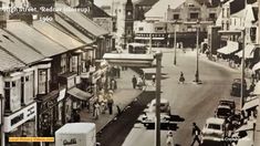 an old black and white photo of people walking down the street