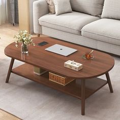 a living room with a couch, coffee table and laptop on top of the table