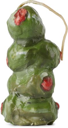 a green sculpture with red berries on it