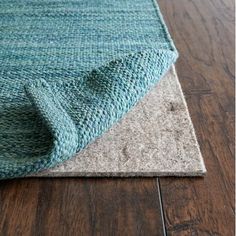 a close up of a rug on the floor with a wooden floor in the background