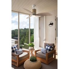 a living room filled with furniture and a large window overlooking the trees outside in front of it