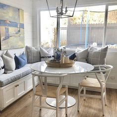 a living room filled with furniture and a white table in front of a large window