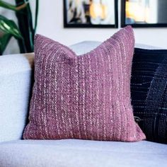 two pillows sitting on top of a white couch