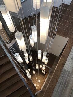 an overhead view of a staircase with many lights hanging from it's sides and wood flooring