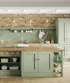 a large kitchen with green cabinets and wooden counter tops, along with an island in the middle